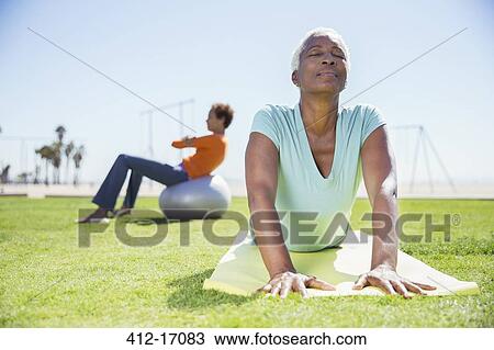 Women practicing yoga in sunny park View Large Photo Image Stock Image - Women practicing yoga in sunny park. Fotosearch