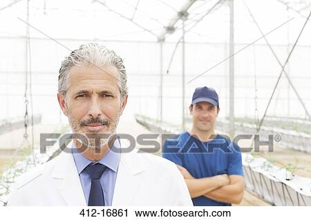 Portrait of confident scientist and worker in greenhouse View Large Photo Image Stock Image - Portrait of confident scientist and worker in greenhouse. Fotosearch