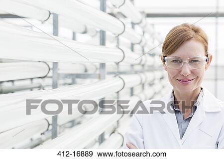 Portrait of confident scientist next to irrigation pipes in greenhouse View Large Photo Image Stock Photo - Portrait of confident scientist next to irrigation pipes in greenhouse. Fotosearch