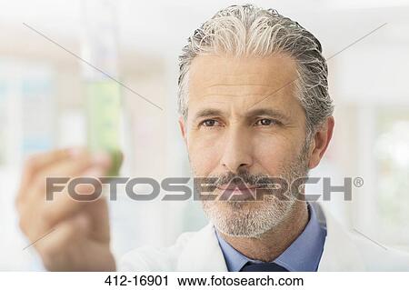 Scientist examining green liquid in tube View Large Photo Image Stock Image - Scientist examining green liquid in tube. Fotosearch