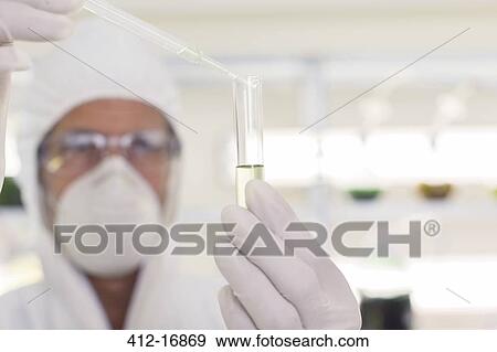 Scientist in clean suit using pipette and test tube in laboratory View Large Photo Image Stock Photo - Scientist in clean suit using pipette and test tube in laboratory. Fotosearch