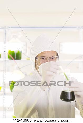 Scientist in clean suit with beaker in laboratory View Large Photo Image Stock Image - Scientist in clean suit with beaker in laboratory. Fotosearch