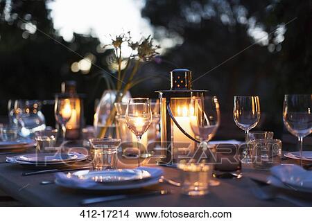 Candles in lanterns on patio dining table with place settings View Large Photo Image Picture - Candles in lanterns on patio dining table with place settings. Fotosearch