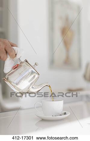 Hand pouring tea from silver teapot View Large Photo Image Stock Image - Hand pouring tea from silver teapot. Fotosearch