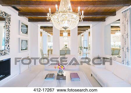 Stock Photo - Illuminated chandelier over luxury living room. Fotosearch