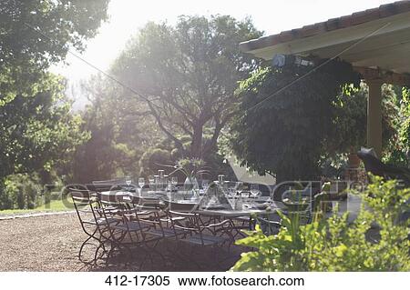 Place settings on sunny rural patio table View Large Photo Image Stock Photography - Place settings on sunny rural patio table. Fotosearch