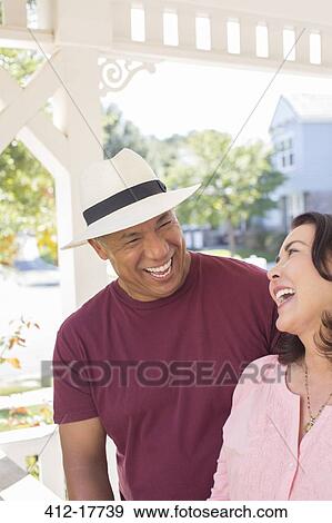 Couple laughing on sunny porch View Large Photo Image Stock Photo - Couple laughing on sunny porch. Fotosearch
