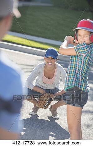 Family playing baseball in street View Large Photo Image Stock Photo - Family playing baseball in street. Fotosearch