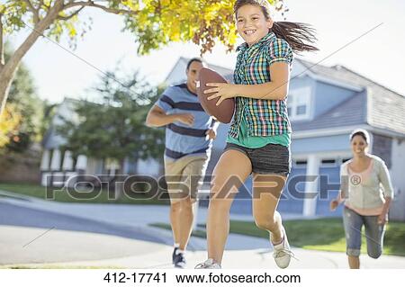 Family playing football in sunny street View Large Photo Image Stock Image - Family playing football in sunny street. Fotosearch