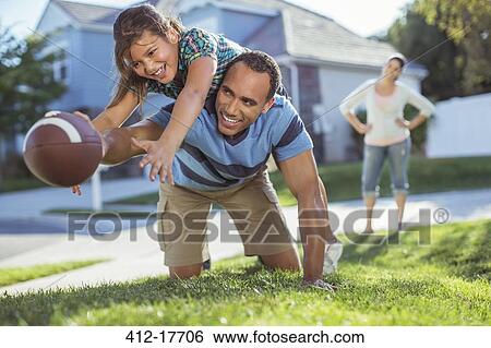 Father and daughter playing football in yard View Large Photo Image Stock Photograph - Father and daughter playing football in yard. Fotosearch