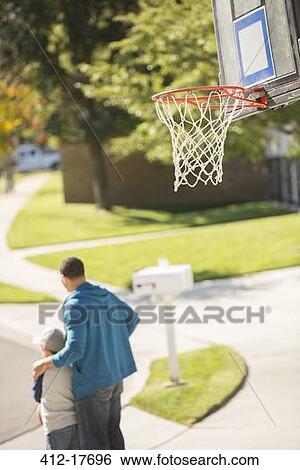 Father and son hugging near basketball hoop View Large Photo Image Stock Photograph - Father and son hugging near basketball hoop. Fotosearch