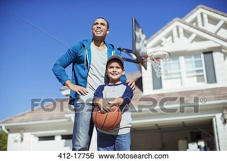 Father and son with basketball in driveway View Large Photo Image Stock Photograph - Father and son with basketball in driveway. Fotosearch