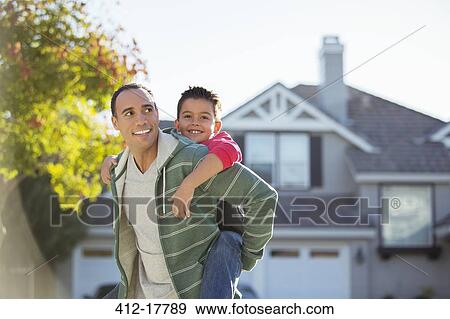 Father piggybacking son outdoors View Large Photo Image Stock Photo - Father piggybacking son outdoors. Fotosearch