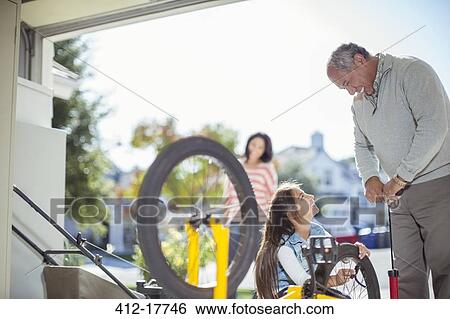 Grandfather and granddaughter inflating bicycle tire in garage View Large Photo Image Stock Photograph - Grandfather and granddaughter inflating bicycle tire in garage. Fotosearch
