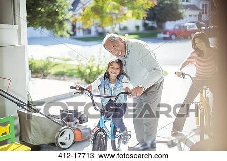 Grandfather and granddaughter on bike in garage View Large Photo Image Stock Image - Grandfather and granddaughter on bike in garage. Fotosearch