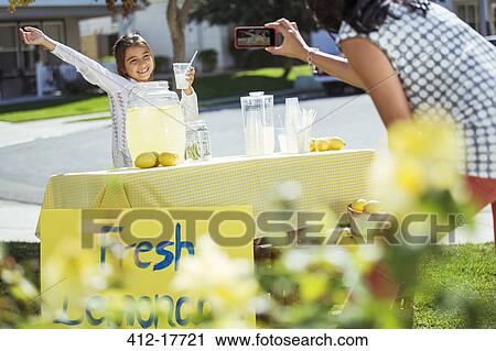 Mother photographing daughter at lemonade stand View Large Photo Image Stock Image - Mother photographing daughter at lemonade stand. Fotosearch