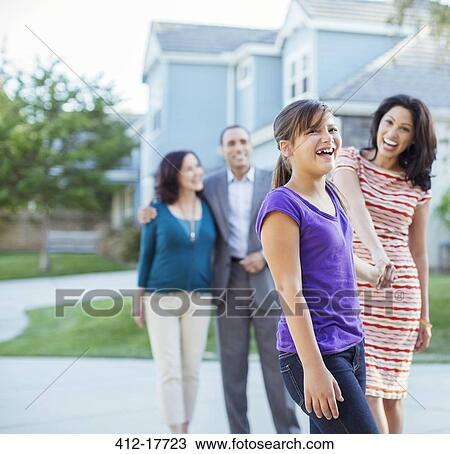 Stock Image - Multi-generation family walking outside house. Fotosearch