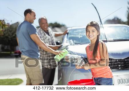 Multi-generation family washing car in sunny driveway View Large Photo Image Stock Image - Multi-generation family washing car in sunny driveway. Fotosearch