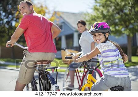 Portrait of family riding bikes on street View Large Photo Image Stock Photo - Portrait of family riding bikes on street. Fotosearch