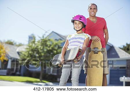 Stock Photography - Portrait of father and daughter with skateboards. Fotosearch