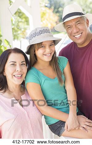 Stock Image - Portrait of happy grandparents and granddaughter. Fotosearch