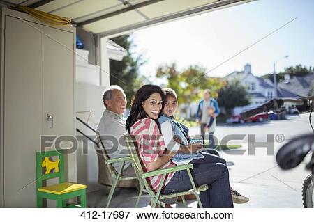 Stock Photo - Portrait of mother and daughter smiling in garage. Fotosearch