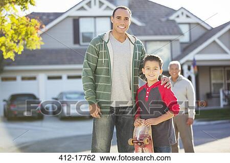 Stock Image - Portrait of multi-generation men in driveway. Fotosearch