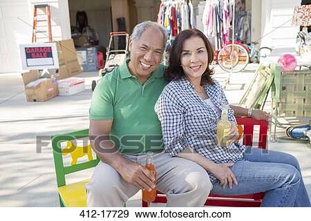 Portrait of smiling couple drinking soda at yard sale View Large Photo Image Stock Photo - Portrait of smiling couple drinking soda at yard sale. Fotosearch