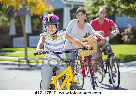 Portrait of smiling family riding bikes in street View Large Photo Image Stock Image - Portrait of smiling family riding bikes in street. Fotosearch