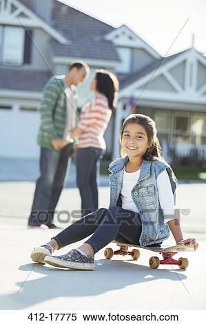 Portrait of smiling girl on skateboard in driveway View Large Photo Image Stock Photography - Portrait of smiling girl on skateboard in driveway. Fotosearch