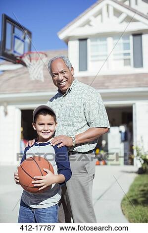 Portrait of smiling grandfather and grandson in sunny driveway View Large Photo Image Stock Photo - Portrait of smiling grandfather and grandson in sunny driveway. Fotosearch
