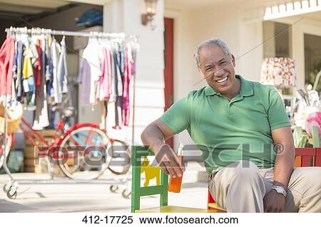 Portrait of smiling man at yard sale View Large Photo Image Stock Photography - Portrait of smiling man at yard sale. Fotosearch