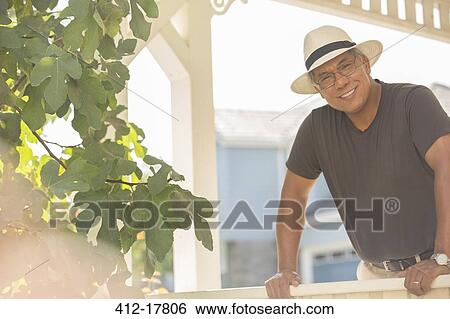 Stock Photograph - Portrait of smiling man on sunny porch. Fotosearch
