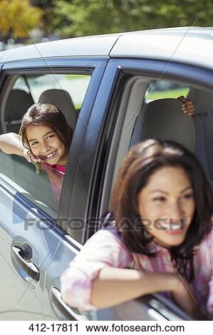 Stock Image - Portrait of smiling mother and daughter in car. Fotosearch