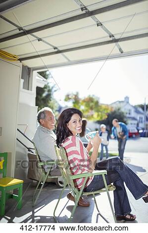 Portrait of smiling woman drinking coffee in garage View Large Photo Image Picture - Portrait of smiling woman drinking coffee in garage. Fotosearch