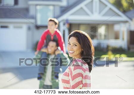 Portrait of smiling woman with family on street View Large Photo Image Stock Image - Portrait of smiling woman with family on street. Fotosearch
