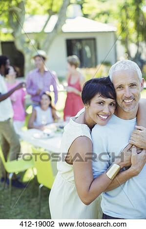 Stock Image - Couple hugging at party. Fotosearch