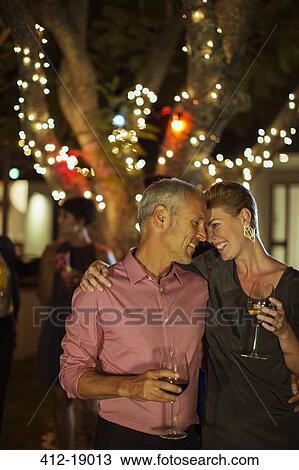 Stock Image - Couple hugging at party. Fotosearch