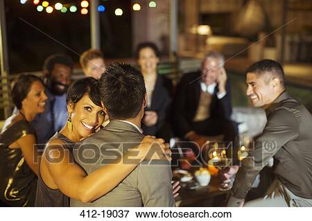 Stock Photo - Couple hugging at party. Fotosearch