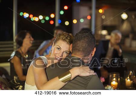 Couple hugging at party View Large Photo Image Stock Photograph - Couple hugging at party. Fotosearch