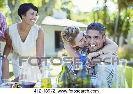 Couple kissing at table outdoors View Large Photo Image Stock Image - Couple kissing at table outdoors. Fotosearch