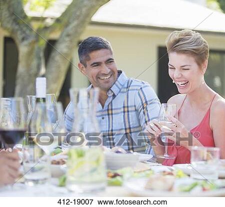 Couple laughing at table outdoors View Large Photo Image Stock Photo - Couple laughing at table outdoors. Fotosearch