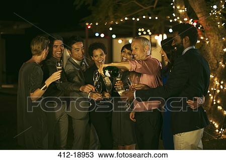 Friends celebrating with champagne at party View Large Photo Image Stock Image - Friends celebrating with champagne at party. Fotosearch