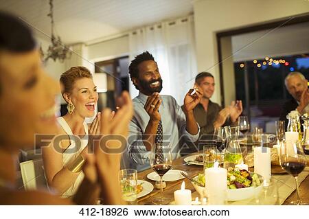 Friends cheering at dinner party View Large Photo Image Stock Photograph - Friends cheering at dinner party. Fotosearch