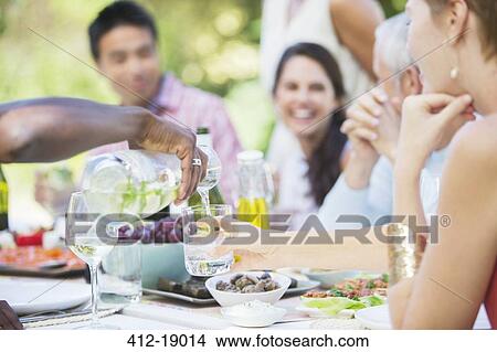 Picture - Friends eating together outdoors. Fotosearch