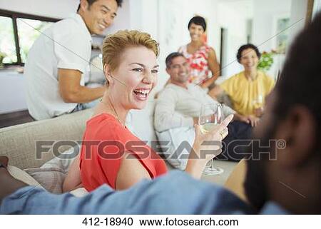 Stock Image - Friends laughing together at party. Fotosearch