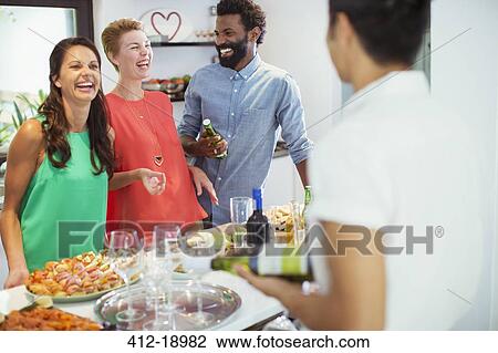 Stock Image - Friends laughing together at party. Fotosearch