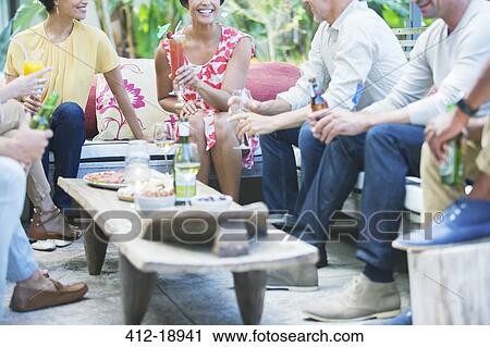 Friends relaxing together at party View Large Photo Image Stock Image - Friends relaxing together at party. Fotosearch