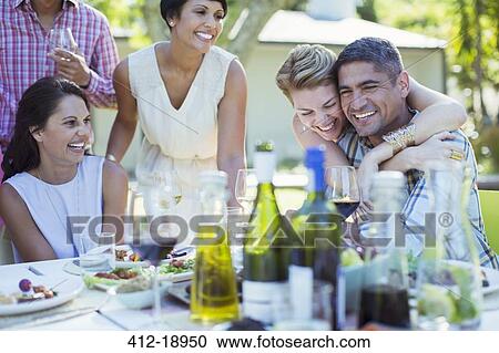 Friends relaxing together at party View Large Photo Image Stock Image - Friends relaxing together at party. Fotosearch