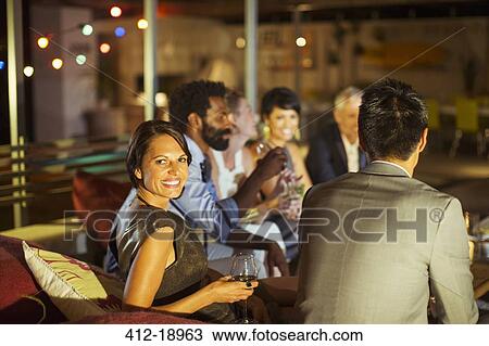 Friends relaxing together at party View Large Photo Image Stock Image - Friends relaxing together at party. Fotosearch
